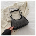 Detail of black leather rhinestone bag with silver chain on beige blazer and magazine - Silver