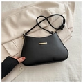 Detail of minimalist black leather underarm bag featuring elegant gold metal hardware and knotted strap - Black