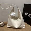 Creamy white oversized faux leather tote bag with plush charm on woven mat background - White + White Plush Charm