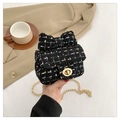 Close-up of black tweed mini bag featuring a large bow and gold metal chain strap - Black