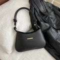 Minimalist black leather underarm bag with gold metal trim and knotted strap detail - Black