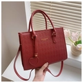 Détail d'un sac cabas rouge matelassé avec lettrage doré et pendentif en cœur - Rouge