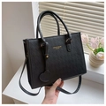 Détail du sac cabas matelassé noir avec lettres dorées et breloque cœur près d'une fenêtre - Noir