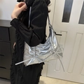 Zilveren metallic schoudertas met plooien, strikken en kettingband gedragen door model - Zilver