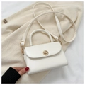 Dettaglio mini borsa bianca in pelle PU con chiusura dorata su sfondo di velluto - Bianco