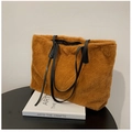 Grand sac cabas en peluche marron avec anses en cuir noir posé sur un livre blanc - Marron