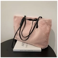 Primer plano del bolso tote de piel sintética rosa con asas de cuero negro sobre libros - Rosa