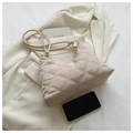 Dettaglio borsa a tracolla beige trapuntata con cuciture a rombi su sfondo blazer moderno - Cachi chiaro