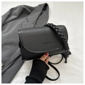 Detail van zwarte crossbody tas van kiezelleder met geweven handvat en paardenhanger - Met Olifanthanger / Zwart