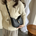 Sac bandoulière demi-lune noir minimaliste avec boucle dorée porté par un mannequin - Noir