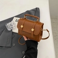 Vintage brown crossbody small square bag with top handle and gold rivets in a lifestyle setting - No Pendant / Brown