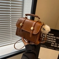 Vintage brown leather crossbody bag with pebble texture and plush monster charm - Brown with White Plush Charm