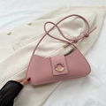 Schicke rosa baguette-tasche mit runder schnalle auf einem beigen blazer-hintergrund - Rosa