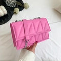 Borsa a tracolla rosa geometrica con catena in metallo argentato in mano - Rosa