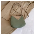 Detalle del bolso tipo cubo bicolor con textura de lichi y barra metálica dorada - Verde