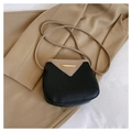 Detalle del bolso de cubo bicolor con adorno dorado sobre una elegante chaqueta caqui - Negro
