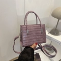 Kleine lila Handtasche mit Krokodil-Prägung, Doppelgriffen und silbernen Beschlägen - Lila