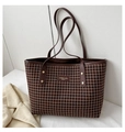 Detail van de grote houndstooth tote tas met premium lederen stiksels en merklabel op de tas - koffiekleur