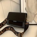 Bolso bandolera negro mate con correa ancha decorativa y herrajes dorados - Negro