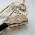 Elegant beige leather crossbody bag with golden H-shaped clasp on a white blazer - Khaki