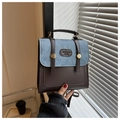 Detail of vintage patchwork handbag with denim blue fabric and brown leather textures - Coffee