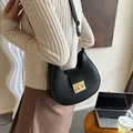 Chic black crescent underarm bag with a gold metal buckle worn by a model - Black