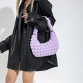 Bolso de axila plisado con textura de burbuja de nube lila llevado por modelo en negro - Morado