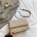 Beige quilted chain crossbody bag with modern geometric pattern on white bedding - Khaki