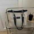 Grande borsa tote in paglia bianco off-white con bordo nero e tracolla a catena su scaffale - Nero