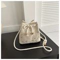 Beige gewebte Beuteltasche mit Blumenstickerei und Kordelzug auf einem schwarzen Tisch - Gebrochenes Weiß