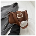Close-up of retro brown underarm bag with large metal buckle and adjustable shoulder strap - Brown