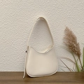 Bolso de hombro media luna blanco crema en cuero sintético sobre superficie madera - Blanco Roto