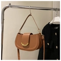 Detail of brown semi-circle saddle bag hanging with golden crescent metal buckle closure - Tan