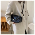 Classic black leather saddle bag with gold metal hardware shown on a shoulder - Black