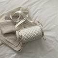 White quilted cylinder crossbody bag made of PU leather with woven strap on white fabric - White