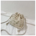 Détail du sac seau en paille avec broderie florale et bandoulière à cordon crème - Blanc