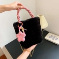 Schicke schwarze Kunstfell-Beuteltasche mit rosa geflochtenem Griff und Blumenanhänger - Schwarz Mit Blumenanhänger