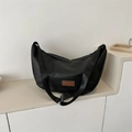 Fashionable black hobo bag in soft fabric with brown leather patch on white display - Black (Without Charm)