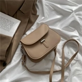Minimalistische khakifarbene Satteltasche mit silberner Metallschnalle auf weißem Stoff - Khaki