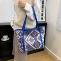 Ethno-Stil gewebte Tote-Tasche mit blauen Ledergriffen in einer Lifestyle-Szene - Blau