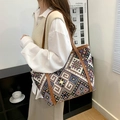 Große Ethno-Stofftasche mit braunen Ledergriffen im lässigen Schulter-Stil getragen - Gelbbraun