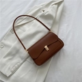 Minimalist vintage brown leather saddle bag with gold metal clasp on a white blazer - Brown