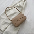 Minimalist light brown faux leather saddle bag with golden buckle on a white blazer - Khaki