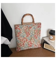 Detailed shot of large floral canvas tote bag featuring unique bamboo round handles on wood - Red Small Flower