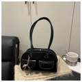 Dettaglio borsa baguette in camoscio nero con ciondolo a ciliegia su maglia morbida - Nero con ciondolo