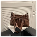Dettaglio di una borsa a spalla marrone plissettata con un grande fiocco e rivetti a stella - caffè
