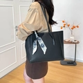 Bolso tote de cuero negro con pañuelo de seda en el asa llevado por modelo en interior - Negro