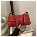 Minimalist red faux leather shoulder bag with buckle detail on books backdrop - Red