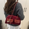 Burgundy mixed-texture underarm bag with cherry pendant shown on shoulder - With Cherry Pendant / Burgundy
