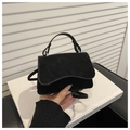 Detail of a matte black leather handbag with a rounded flap and elegant top handle - Black